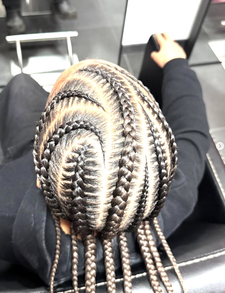 Strakke cornrows met decoratief vlechtwerk op het hoofd